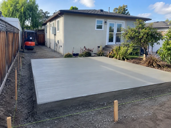 Freshly poured concrete slab-on-grade foundation for a detached backyard ADU